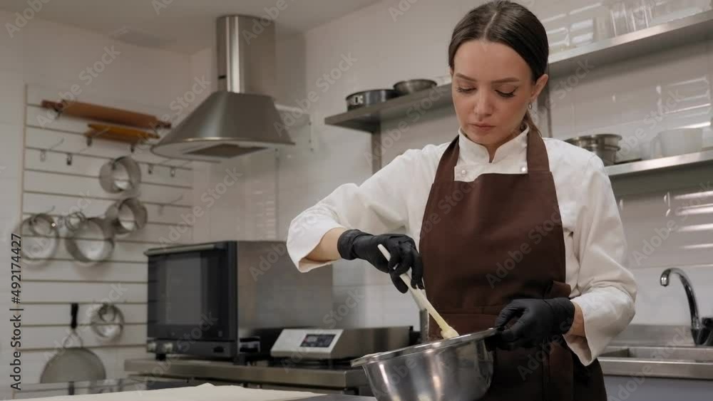 The pastry chef mixes pistachio mousse and whipped milk cream in a professional kitchen, the process of making mousse cake. The pastry chef mixes pistachio mousse and whipped milk cream in a professional kitchen, the process of making mousse cake.