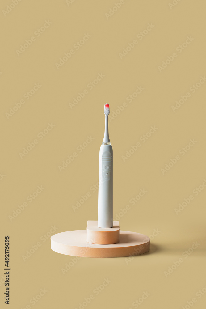White pink electric toothbrush on the podiums on beige background. Copy space White pink electric toothbrush on the podiums on beige background. Copy space