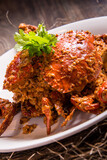 wok fried big fresh meat crab seafood in salted egg yolk paste sauce on wood table chinese banquet halal menu