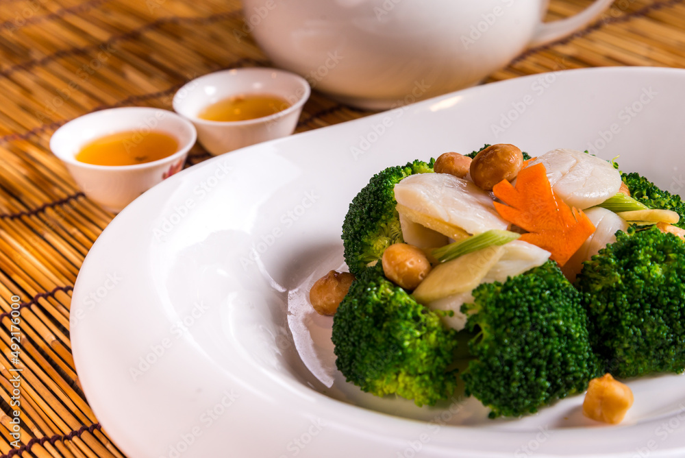 stir fried vegetable broccoli and asparagus with scallop in soy sauce on bamboo background chinese banquet menu