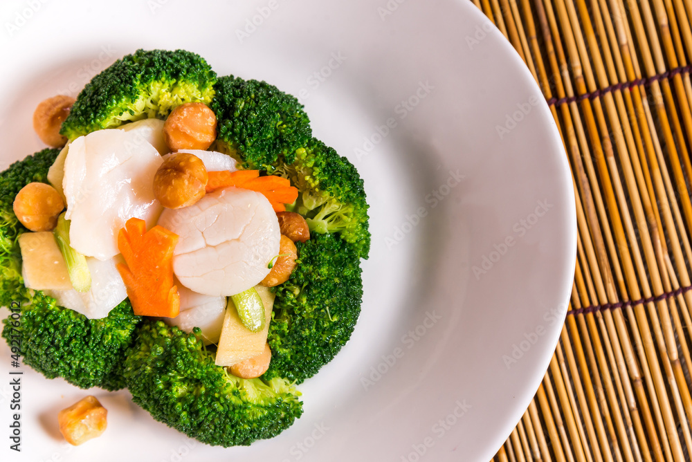 stir fried vegetable broccoli and asparagus with scallop in soy sauce on bamboo background chinese banquet menu stir fried vegetable broccoli and asparagus with scallop in soy sauce on bamboo background chinese banquet menu