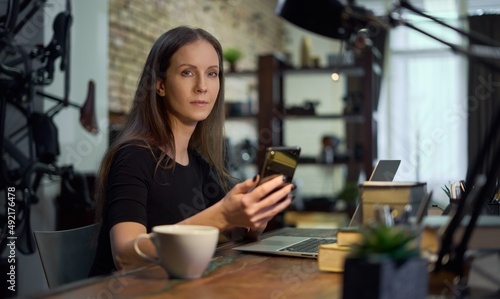 Businesswoman working with laptop computer and phone in home office. Woman using the internet, searching, browsing, Entrepreneur managing small business online.