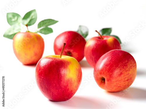 Bright apples with leaves on a white background