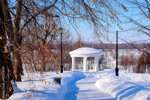 Snow-covered path to the gazebo on the river bank