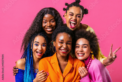 Beautiful black women posing with colorful casual clothes in studio on colored background