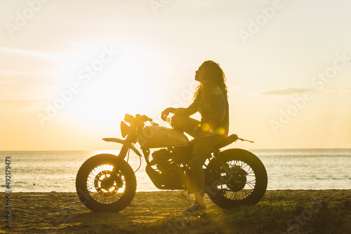 Canvas Print Female biker driving a cafe' racer motorbike