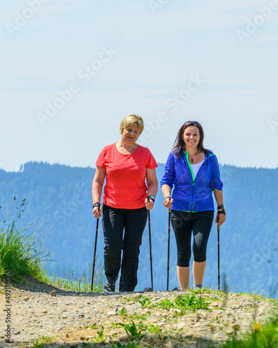 Zwei gutgelaunte Frauen beim Nordic Walking