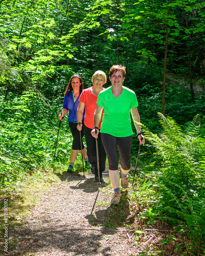 Drei Frauen genießen die frische und gesunde Luft beim Nordic Walking im Wald