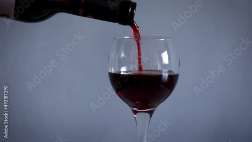 Close up filling wine glass with red wine photo