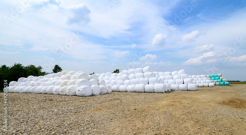 Hay bales on a rural countryside farmland ready for livestock wrapped in plastic