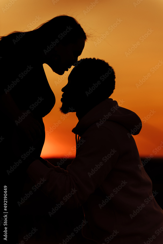 Sunset couple. Happy marriage couple at the field, overjoyed husband kiss pregnant tummy of beautiful wife, young family expect for a baby, excited about parenthood, weekends outdoors concept