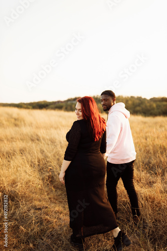 Beautiful couple walking at the field  attractive husband holding hands adorable wife  overjoyed woman smiling  happy family spend time together  weekends outdoors concept