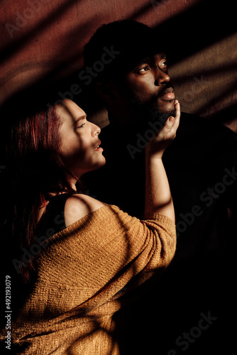 Portrait of attractive African American man gently cuddle beautiful white woman, adorable lady enjoy tender moments, spend time together, mixed race couple concept