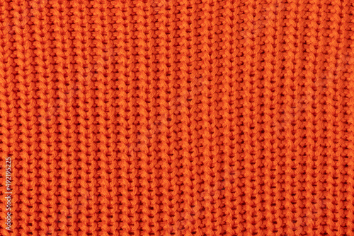 Knitted orange fabric. Texture background.