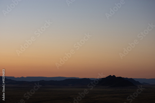 Pastel sky over Namibian landscape seen at sunrise from aerial view