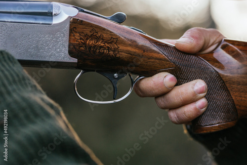 Close up view of a hunter man aiming with a gun to his prey.