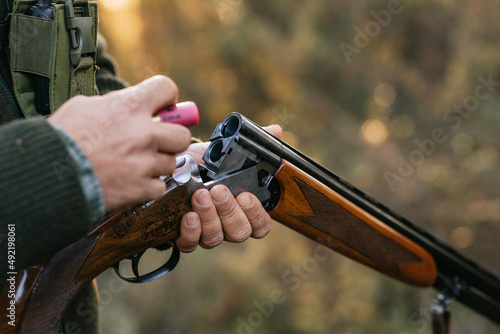 Hunter man loading his gun while hunting outdoors. Fototapet