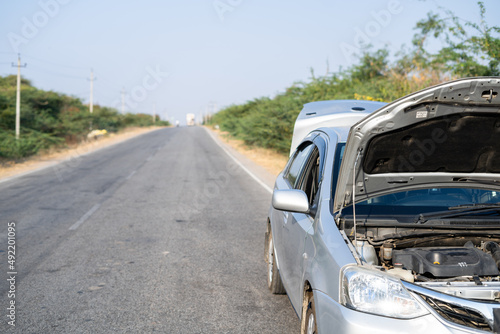 Broken or crashed car with opened hood left on highway road - concept of accident and failure