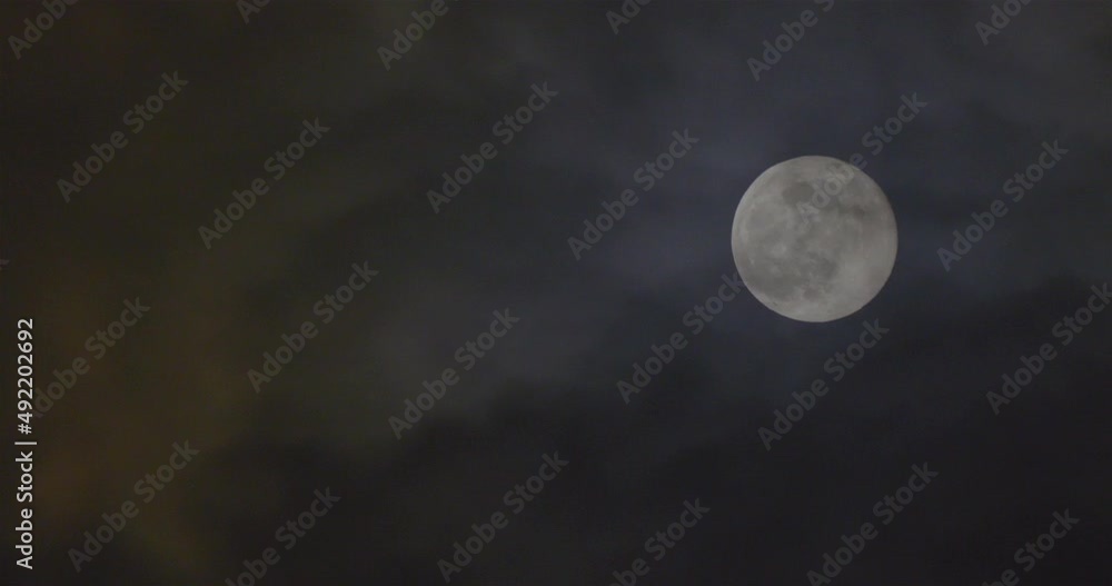 Full moon and windblown clouds in the night sky.