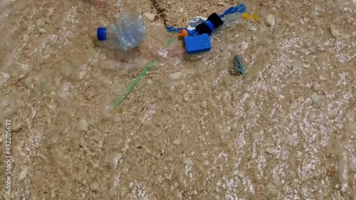 Plastic trash or garbage pollution on the sand beach with water