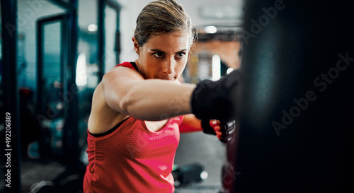 Its about the follow-through. Cropped shot of an attractive young female kickboxer working out in the gym.
