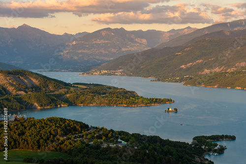 Serre-Poncon lake in the Hautes-Alpes (Alps). Sunset light on the village of Savines-le-Lac and Saint-Michel Bay. France