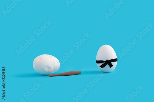 Funny Easter layout with white eggs  one wearing black karate belt and one having baseball bat