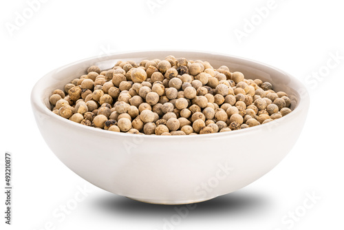 Side view closeup of white pepper in ceramic cup on white background.