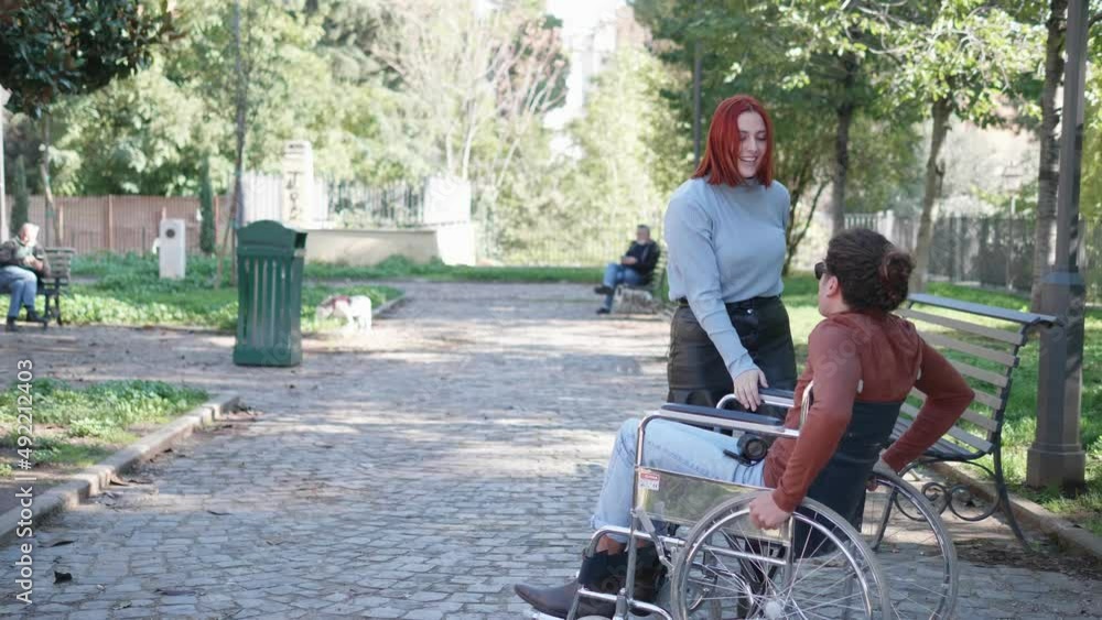 empathy, solidarity - young woman makes her disabled friend dance empathy, solidarity - young woman makes her disabled friend dance