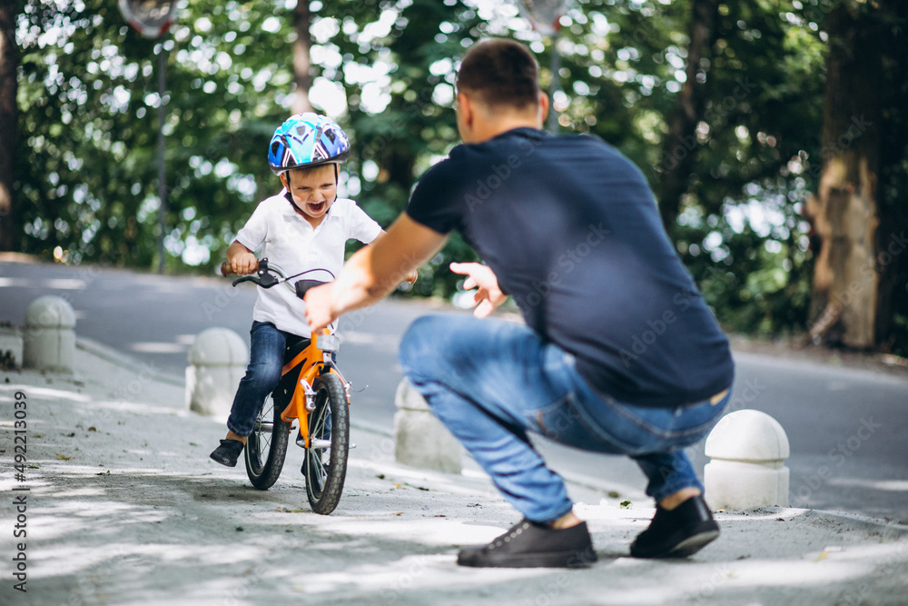 Fototapeta premium Father teaching his little son to ride a bicycle