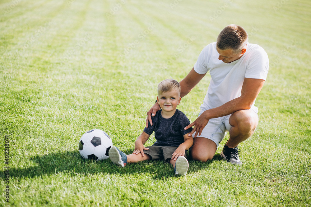 Father with son playing football at the field
