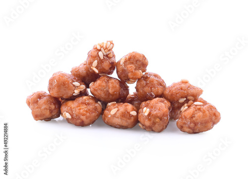 Honey covered, coated peanuts with sesame seeds isolated on white background