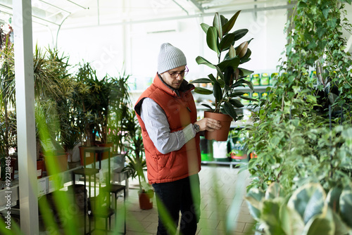 garden center worker moving warehouse new potted plants