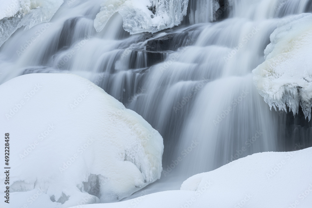 Winter landscape of Bond Falls framed by ice and snow and captured with motion blur, Ottawa National Forest, Michigan's Upper Peninsula, USA Winter landscape of Bond Falls framed by ice and snow and captured with motion blur, Ottawa National Forest, Michigan's Upper Peninsula, USA
