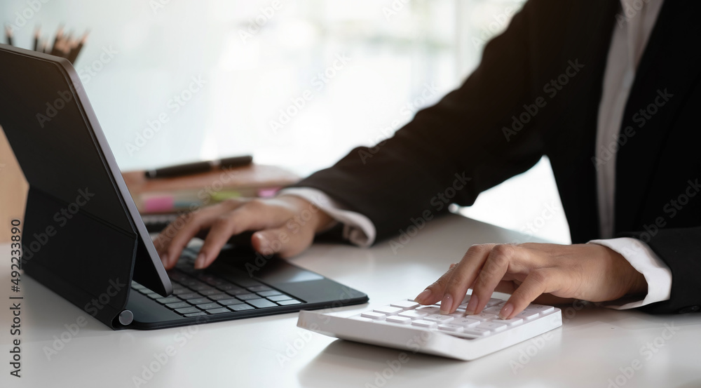 Businesswoman using calculator working at office with laptop reports document financial. Businesswoman using calculator working at office with laptop reports document financial.