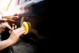 Car clean concept, Hand a man holding a sponge and clean spray wax to take care of the surface of the car from washing