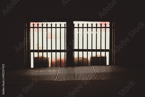 A dark New York street with a brightly lit window at night.