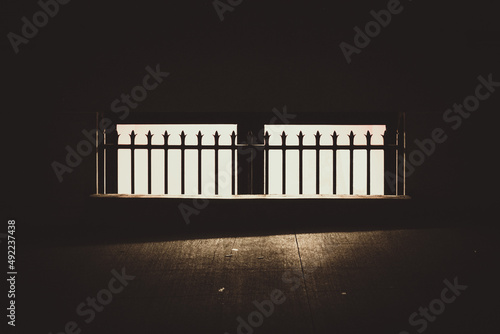 A dark New York street with a brightly lit window at night.