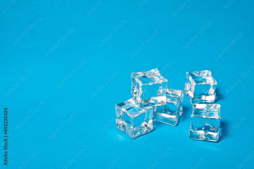Clear ice cubes for cooling drinks on a blue background. Clear ice cubes for cooling drinks on a blue background.