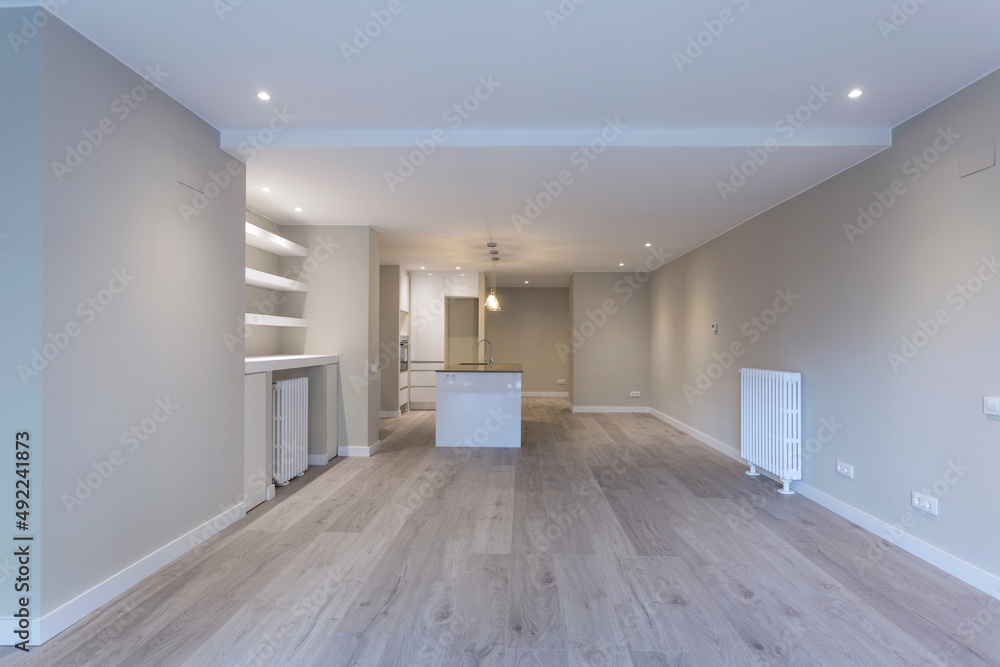large empty living room and kitchen with island in the background large empty living room and kitchen with island in the background