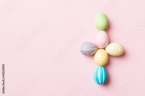 holiday preparation Multi colors Easter eggs on colored background, cross show the religious and secular side of Easter. Pastel color Easter eggs. holiday concept with copy space