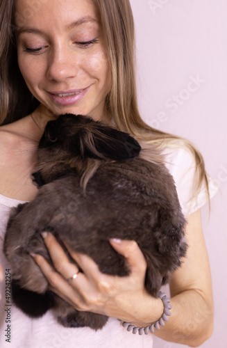 Close-up girl with adorable rabbit indoors  close up. Lovely pet and animal concept