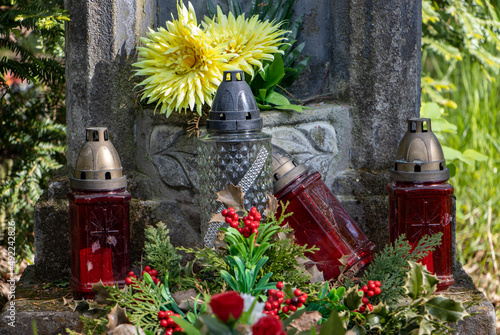 Wall Mural Close up view of a grave full of flowers and lamps
