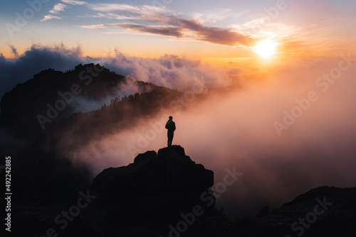Silueta de un hombre mirando hacia el paisaje durante el atardecer photo