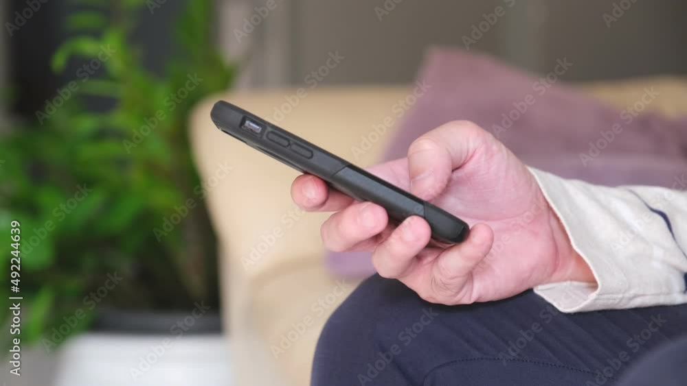 Close up shot of men hand using smart phone for check email for work or sending text SMS short message at home. Mobile wireless digital technology for communication. Close up shot of men hand using smart phone for check email for work or sending text SMS short message at home. Mobile wireless digital technology for communication.