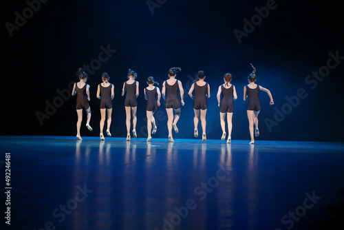 Girls dance on stage. They run forward together.