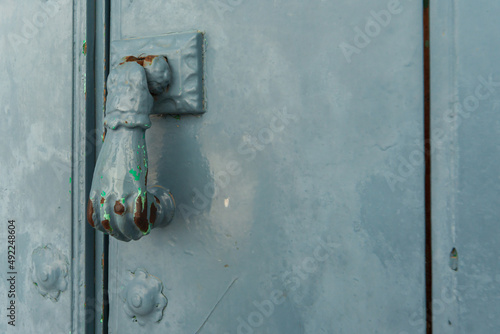 Door with brass knocker in the shape of a hand, beautiful entrance to the house