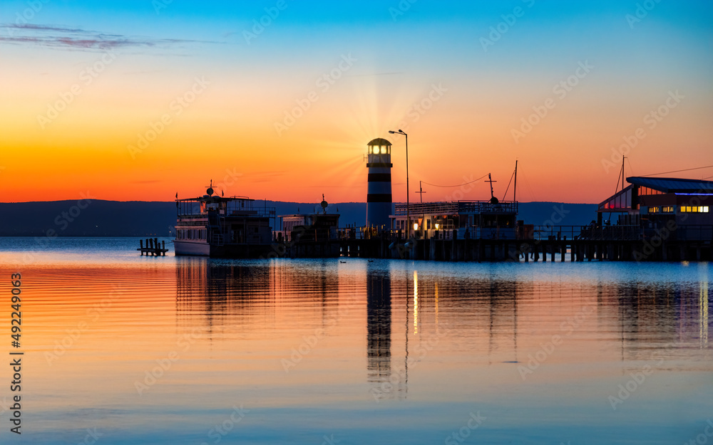 Podersdorf, Austria, lighthouse. Passenger ships at pier during beautiful sunset