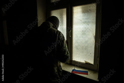 Conceptual photo of war between Russia and Ukraine. Ukraine and Russia flags on windowsill at night. Old creepy room with window. © zef art