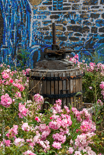 Vieux pressoir à raisin en bois au milieu d'un parterre de fleurs dans le petit village de Montaigut dans le puy de dôme